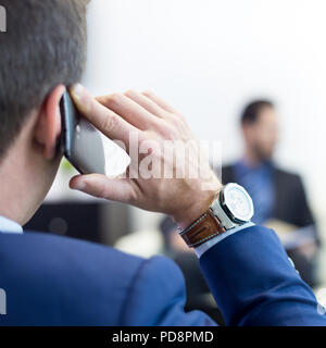Team aziendale alla riunione di affari e il manager parlando al telefono. Foto Stock