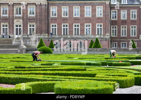 Giardiniere il taglio delle basse siepi di bosso a Nordkirchen Moated Palace, Germania Foto Stock