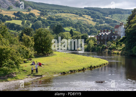 Alloggiamento si affaccia sul fiume Dee che scorre attraverso la Vale of Llangollen, Carrog, Denbighshire, Galles del Nord, Regno Unito. i turisti su Riverside. Foto Stock