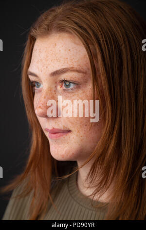 Un colpo di testa di profilo di una giovane donna con i capelli rossi e le lentiggini Foto Stock