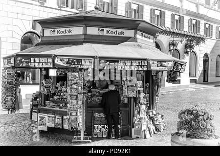 Un anziano gentiluomo effettua un acquisto presso un chiosco in Roma la vendita di prodotti turistici - Biglietti, cartoline, souvenir, giornali, riviste e pellicola Kodak Foto Stock