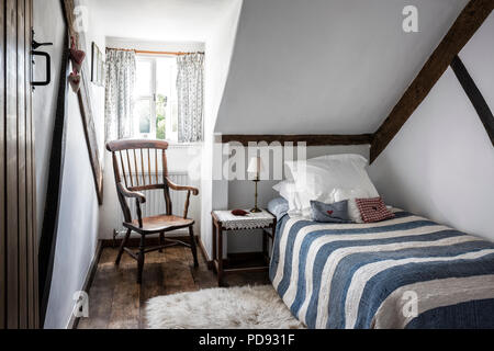 Vintage quilt striato e antichi windsor sedia in mansarda camera per gli ospiti Foto Stock