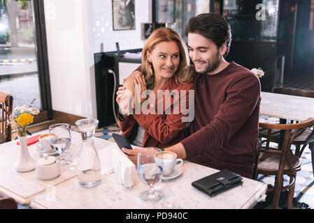 Felice coppia positiva navigando in Internet Foto Stock