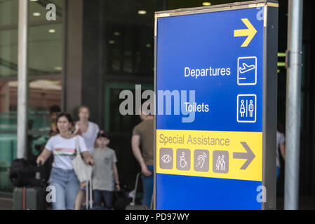 Firmare all'entrata di un aeroporto che mostra i passeggeri dove possono ottenere assistenza speciale. Foto Stock