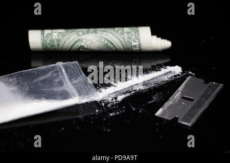 Penale di attività del farmaco. La droga su un tavolo con la cocaina in polvere e una lama di rasoio. Foto Stock