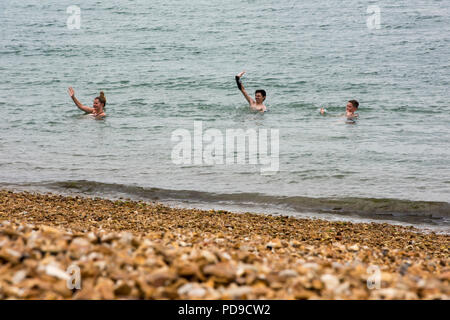 Tre persone a nuotare in mare Foto Stock