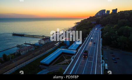 Drone vista mare con il viadotto Matsesta, il Matsesta marine, la stazione ferroviaria e la montagna al tramonto, Sochi, Russia Foto Stock