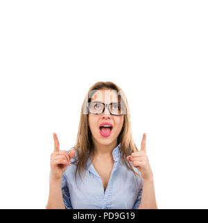 Giovane donna intelligente in bicchieri rivolta verso l'alto con le dita rivelando nuova idea e guardando eccitato su sfondo bianco Foto Stock