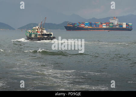 La nave portacontainer KOTA LUKIS, lascia i terminal dei container Kwai Tsing a Hong Kong, in Cina, e si dirige verso il canale Lamma orientale. Foto Stock