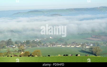 Foschia mattutina oltre il villaggio di Musbury e Ax Valley in East Devon AONB (Area di straordinaria bellezza naturale) Foto Stock