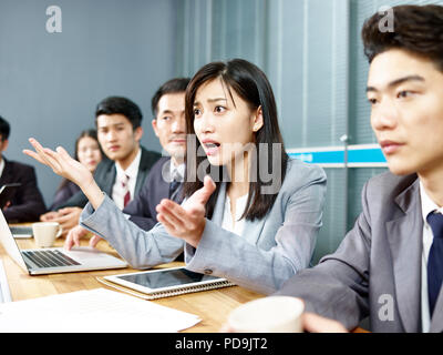 Giovani asian Business Woman Executive che si impegna in una accesa discussione durante la riunione. Foto Stock