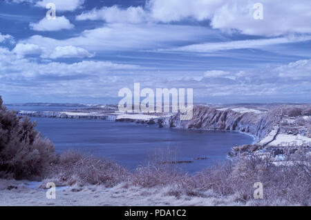 Infrarossi vista panoramico lungo la Jurassic Coast di Lyme Bay guardando verso ovest da Sidmouth, Devon, Inghilterra, Regno Unito su un soleggiato tardo inverno/inizio giornata di primavera. Foto Stock