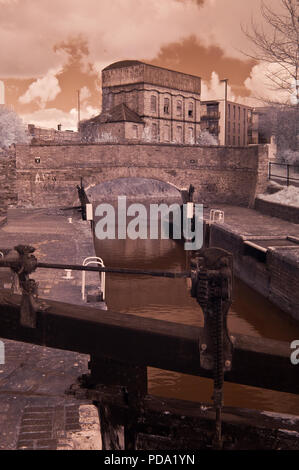 Immagine infrarossa della serratura Firepool in Taunton e Bridgwater Canal nel Somerset, Regno Unito con una vecchia ferrovia water tower in background Foto Stock