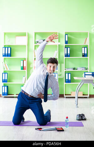 Il dipendente a fare gli esercizi durante la pausa di lavoro Foto Stock