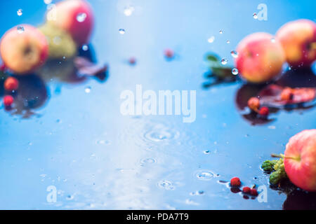 Autunno pioggia telaio con copia spazio. Le mele non focalizzato con gocce di acqua e posto per il testo. Fresca e ariosa Autumn harvest concept Foto Stock