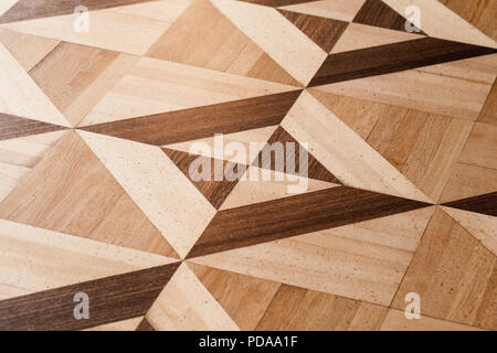 Classico parquet in legno progettazione, disegno geometrico con triangoli e quadrati. Foto di sfondo texture Foto Stock