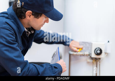 Plumber riparare un hot-calorifero di acqua Foto Stock