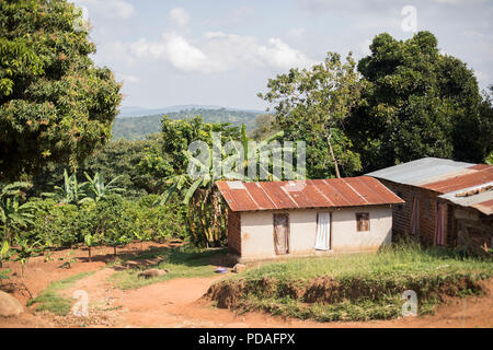 Negozi e case la linea banchina di una piccola città nelle zone rurali del distretto di Mukono, Uganda. Foto Stock