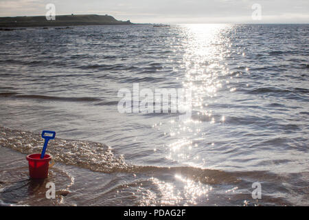 Una benna e vanga seduta su di una spiaggia di sabbia durante una giornata di sole in Sutherland, Highlands della Scozia. Foto Stock