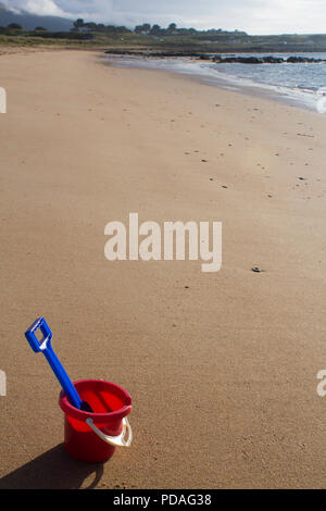 Una benna e vanga seduta su di una spiaggia di sabbia durante una giornata di sole in Sutherland, Highlands della Scozia. Foto Stock
