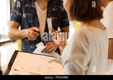 Tourist getting key card dal receptionist dell'hotel. Foto Stock