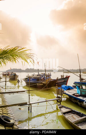 Un gruppo di barche da pesca lungo la spiaggia e tenetevi pronti per la giornata per andare al mare. Hoi An, Vietnam Foto Stock