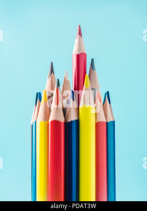 Il concetto di business - matite colorate su carta blu sullo sfondo. È il simbolo del lavoro di squadra, uniti e comunicazione. Foto Stock