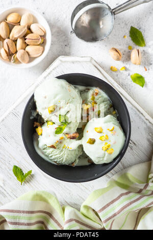 Pistacchi gelato in vaschetta di colore bianco sul tavolo di pietra. Foto Stock