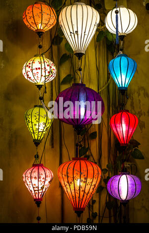 Luminose lanterne colorate contro una parete a Hoi An, VN. Questi sono visualizzati in tutta la città e in molte case e negozi, ristoranti. Questi sul displ Foto Stock