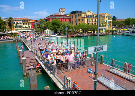 I turisti in attesa sul molo per l'escursione in barca, Sirmione sul Lago di Garda, Lombardia, Italia Foto Stock