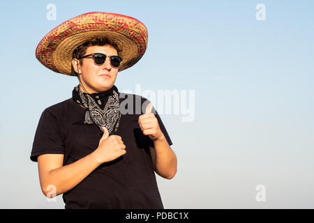 Allegro giovane maschio persona in sombrero nel cielo chiaro dello sfondo. Indipendenza del Messico il concetto di festa di festa uomo che indossa national Mexican Hat e w Foto Stock