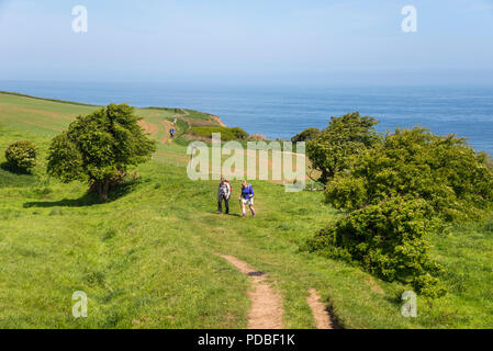 Walkers sul modo di Cleveland sentiero costiero vicino a Kettleness, Whitby, North Yorkshire, Inghilterra. Una soleggiata giornata di primavera. Foto Stock