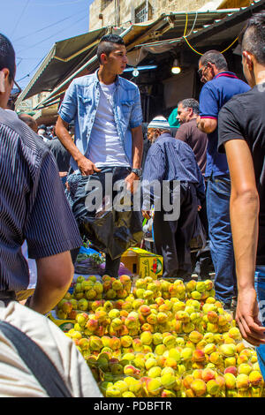 11 maggio 2018 un giovane maschio arabo cercando di vendere le pesche per il passaggio di folla che stanno rispondendo alla chiamata alla preghiera vicino a Damasco abbiamo mangiato a Gerusalemme Foto Stock