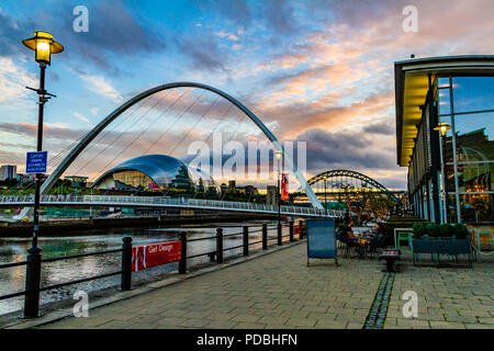 Vista del Fiume Tyne dall'esterno Pitcher & Piano bar, guardando verso il Millennium Bridge, Tyne Bridge e la Salvia al tramonto. Newcastle, Regno Unito. Foto Stock