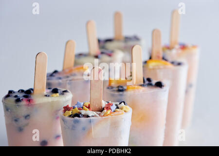Vista ravvicinata di congelato fresco gelato fatto in casa con organici frutti e bacche su grigio Foto Stock