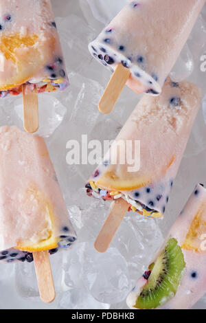 Vista ravvicinata di gourmet popsicles fatti in casa con frutti e bacche su cubetti di ghiaccio Foto Stock
