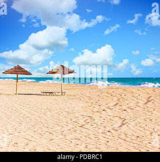 Due ombrelloni di paglia sulla spiaggia Foto Stock