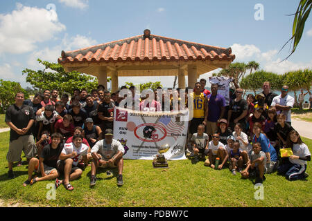 CHATAN, Okinawa, in Giappone - i membri degli STATI UNITI Le forze del Giappone - American Football League posano per la foto durante una giornata di amicizia beach cleanup 4 Agosto sulla Sunset beach seawall in Chatan, Okinawa, in Giappone. Il USFJ - AFL è stato avviato nella speranza che gli enti locali e la comunità militare potrebbe trovare un interesse comune e di costruire solide relazioni di amicizia. Il cleanup ammessi giocatori da tutte le squadre di trascorrere del tempo insieme fuori dal campo di calcio e di lavorare insieme per prendersi cura della loro comunità. (U.S. Marine Corps photo by Lance Cpl. Kelcey Seymour) Foto Stock