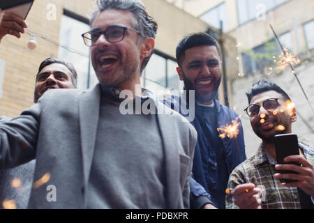 Entusiasta amici maschi celebrando con botti Foto Stock