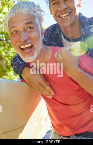 Giocoso padre e figlio piggybacking Foto Stock