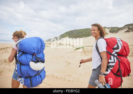 Ritratto maschile felice di parapendio con paracadute zaino sulla spiaggia Foto Stock