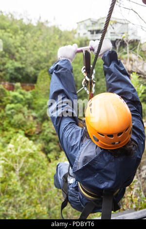 Donna fodera zip sopra gli alberi Foto Stock