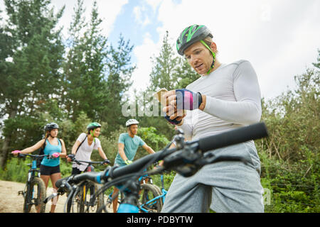 L'uomo mountain bike, utilizzando smart phone nei boschi Foto Stock