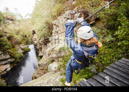 Donna fodera zip su stagno nel bosco Foto Stock