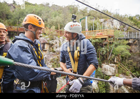 Uomo felice con telecamera indossabile preparando a zip line Foto Stock