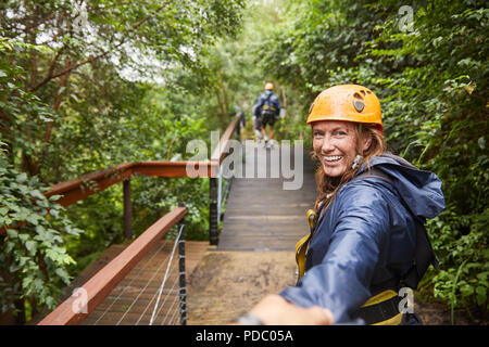 Ritratto di donna sorridente fodera zip nei boschi Foto Stock