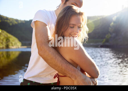 Affettuosa giovane costeggiata a sunny estate lago Foto Stock