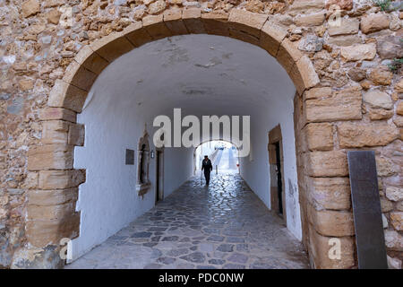 Il vecchio uomo che cammina attraverso l'Arco / Porta de São Gonçalo, muri e la porta della città per la città vecchia di Lagos, Algarve, PORTOGALLO Foto Stock