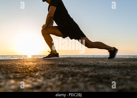 Tagliate di tiro sportivo facendo balzi in avanti durante il corso di formazione sulla riva del mare Foto Stock
