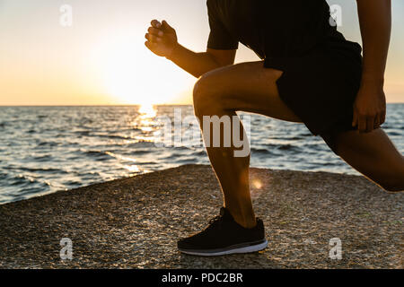 Tagliate di tiro sportivo facendo balzi in avanti durante il corso di formazione sulla riva del mare al mattino Foto Stock